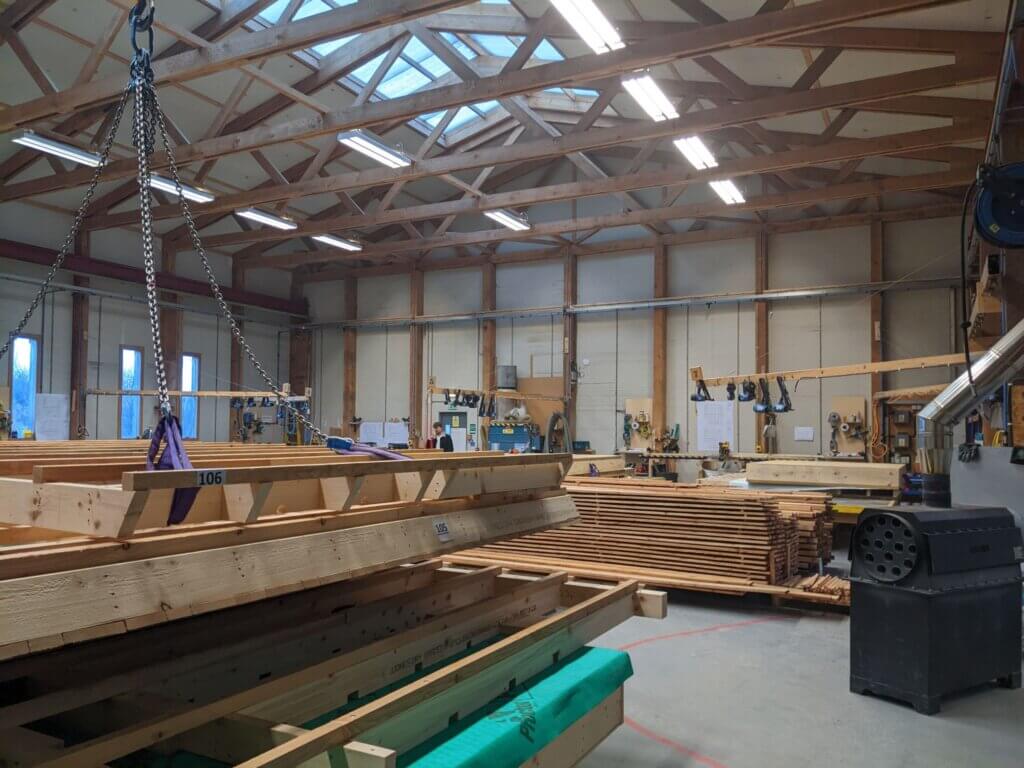 Photo of a factory floor with stacked timber